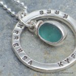 Stamped ring pendant with bezel set sea glass